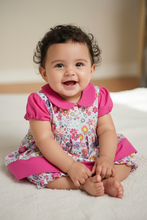 Load image into Gallery viewer, Hispanic baby girl 3-6 months in floral dress with fuchsia collar and sleeves - pose 1
