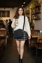 Load image into Gallery viewer, Hispanic woman with wavy brown hair and green eyes wearing black denim crossbody bag - coffee shop cafe