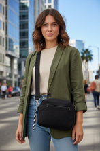 Load image into Gallery viewer, Hispanic woman with wavy brown hair and green eyes wearing black denim crossbody bag - urban city street