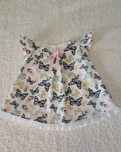 Load image into Gallery viewer, Baby dress with butterfly pattern on a textured surface
